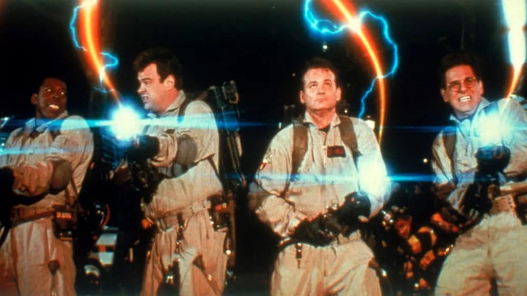 Four men in uniforms with ghost blasters activated in this image from Columbia-Delphi Productions