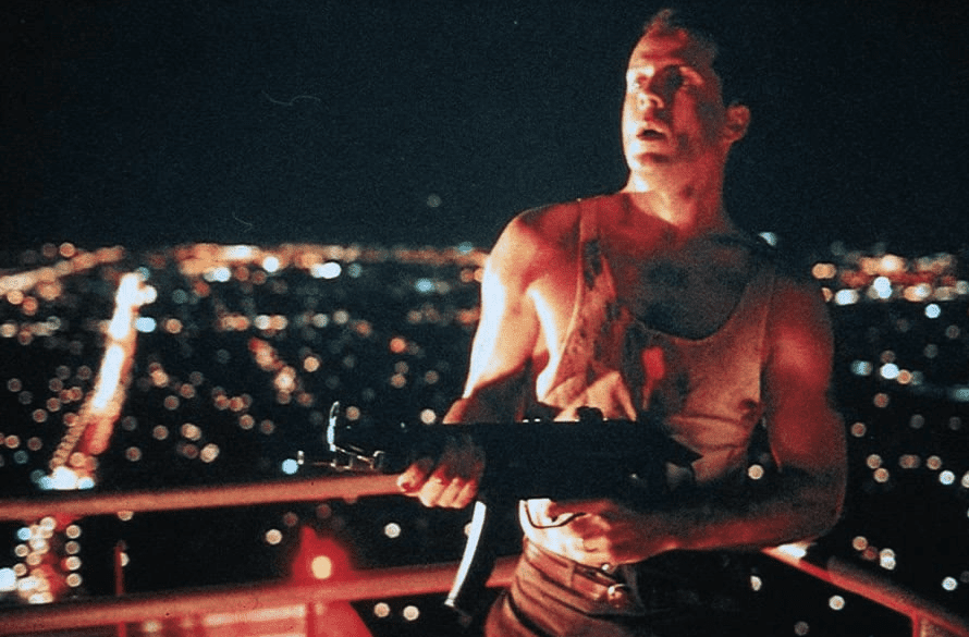  A bloodied man stands on the rooftop of the Nakatomi building with a gun in this image from Twentieth Century Fox.