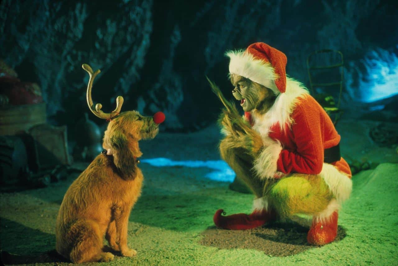 The Grinch, dressed as Santa, explains his plan to Max, dressed as Rudolph.
