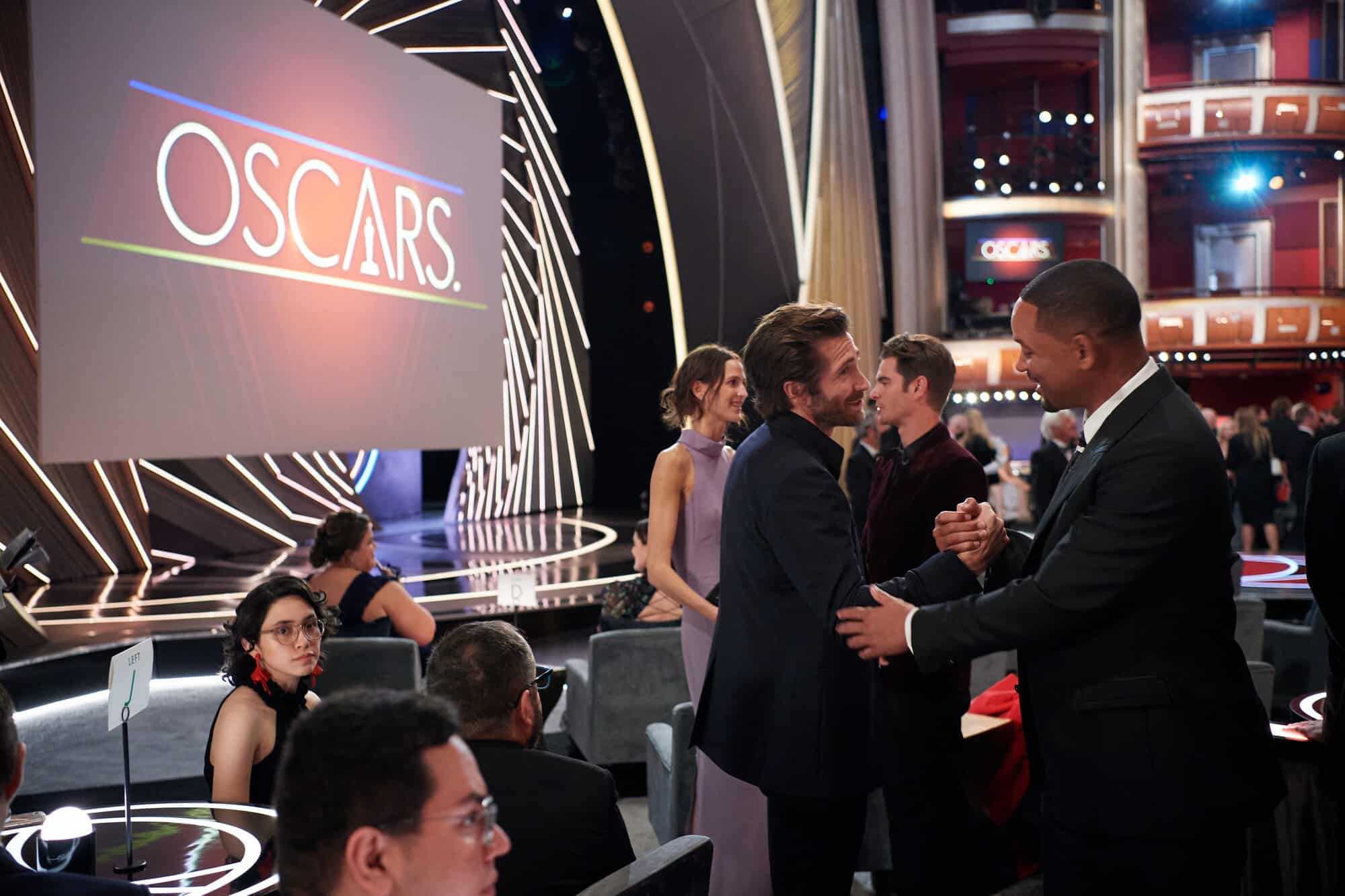 Jake and Will shaking hands in front of the Oscars stage