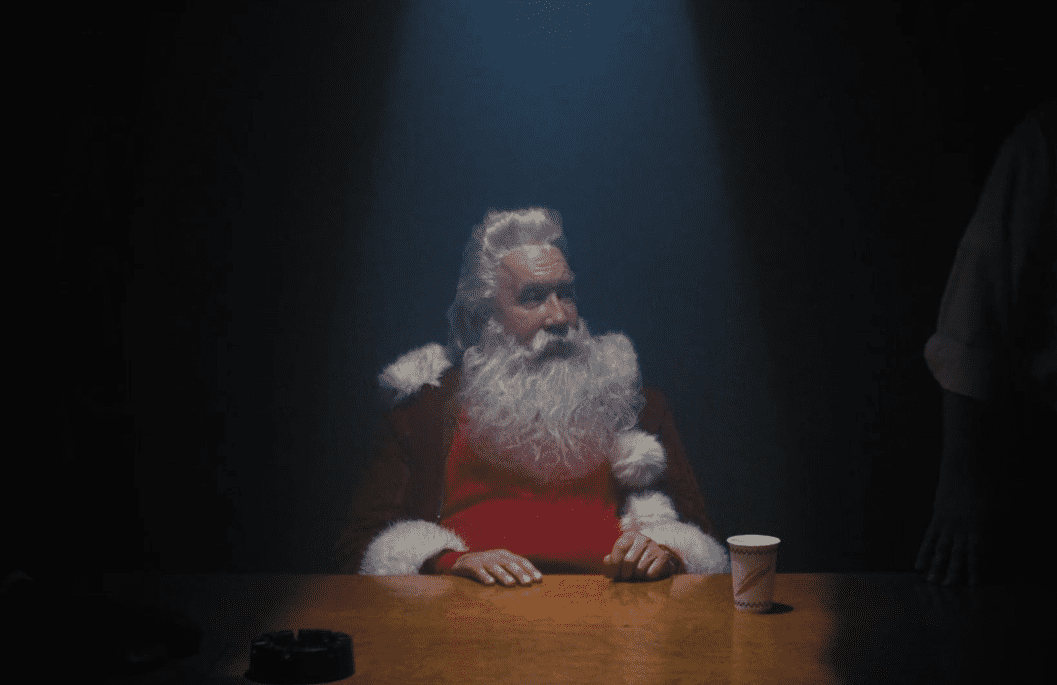 Santa sits in a dimly lit interrogation room.