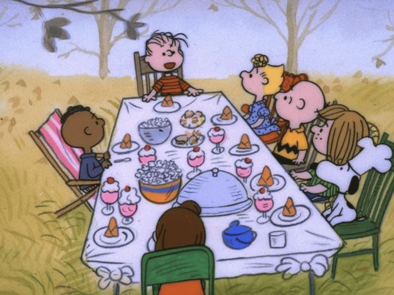  A group of kids and a dog gather at a Thanksgiving table in this image from Lee Mendelson Film Productions. 