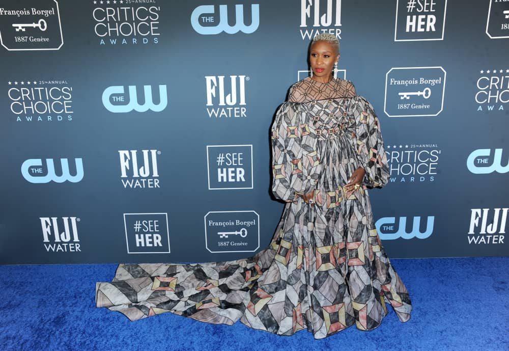 Cynthia Erivo smiles in a couture gown on the blue carpet.