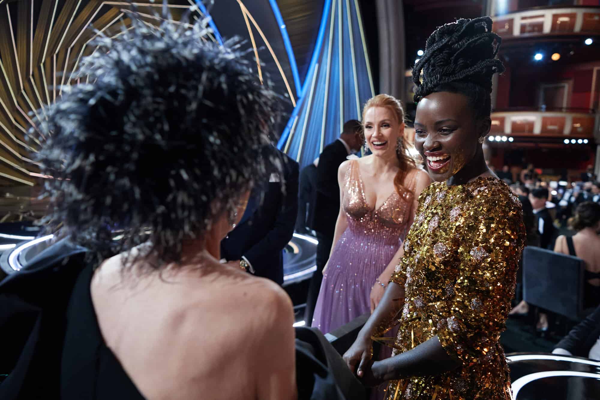 Rita, Jessica, and Lupita laughing in front of the Oscars stage