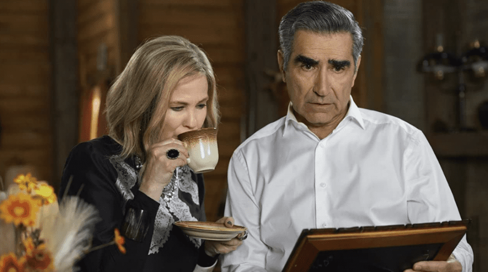 Moira and Johnny Rose looking at a framed photo in “Schitt’s Creek”