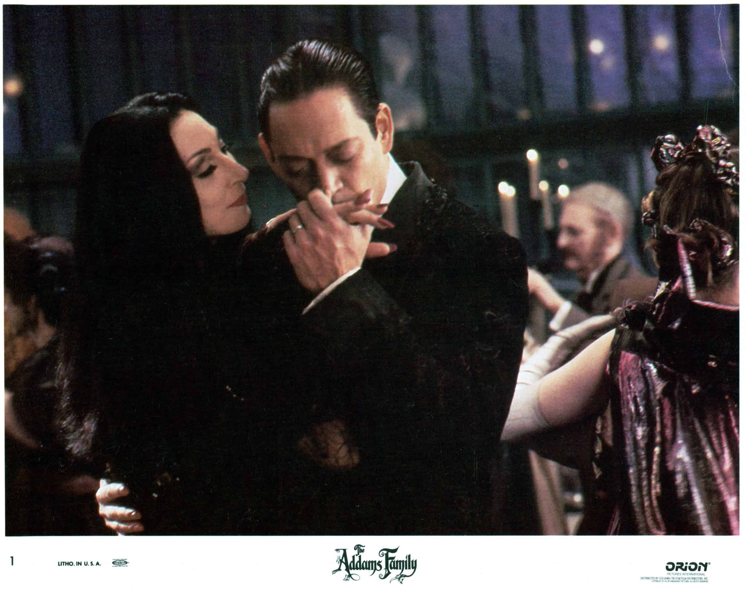 Gomez kisses Morticia's hand as they dance