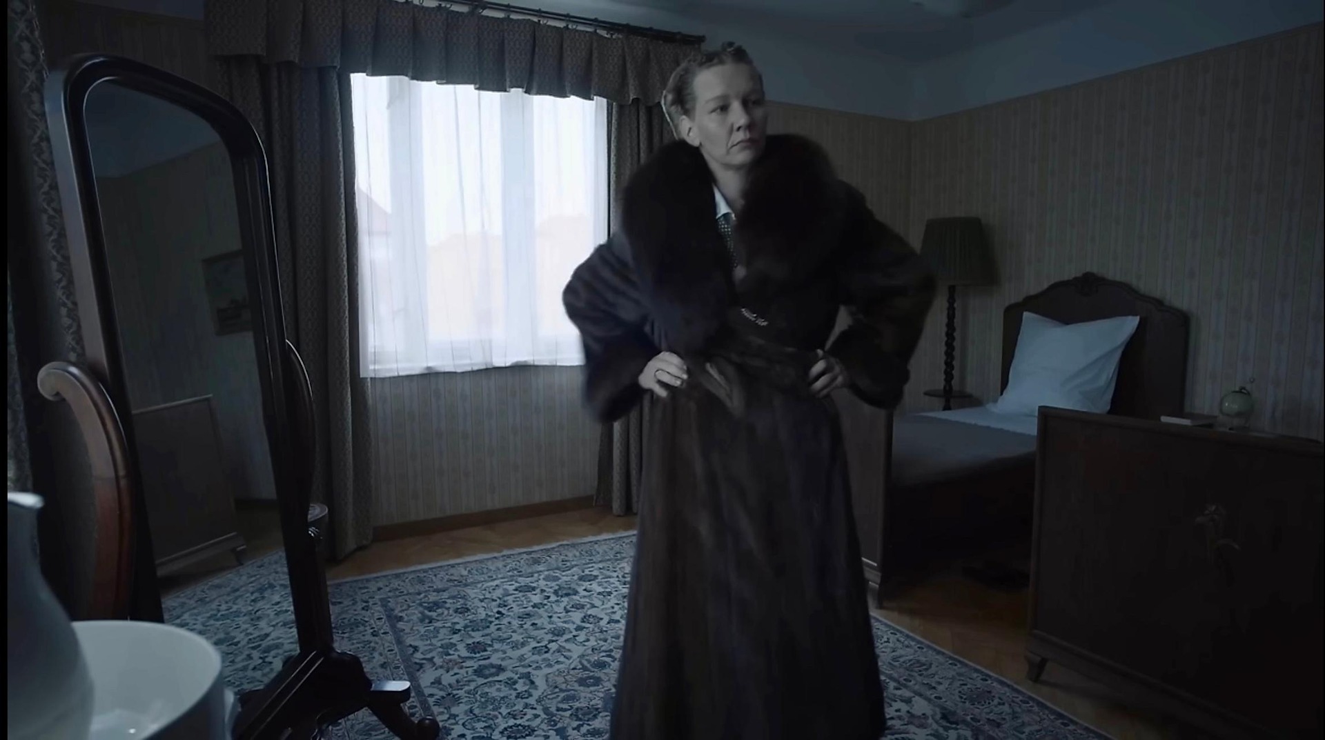 A woman in a fur coat in a bedroom in this image from A24.