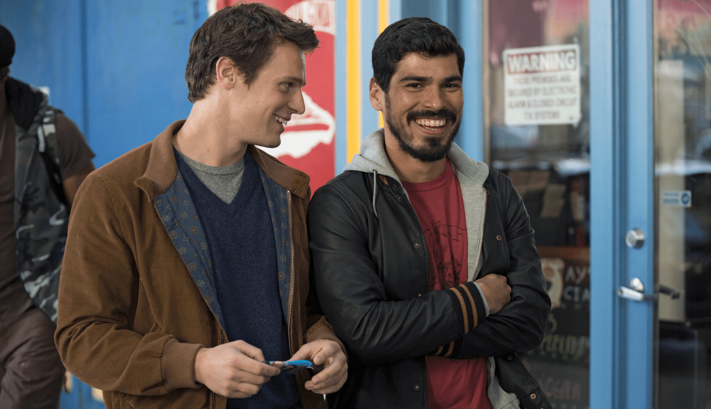 Two of the main cast of Looking walking past a blue shop in San Francisco's Castro district