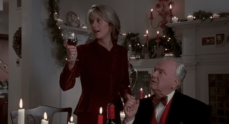 A woman and her father make a toast at the Christmas table in this image from TriStar Pictures. 