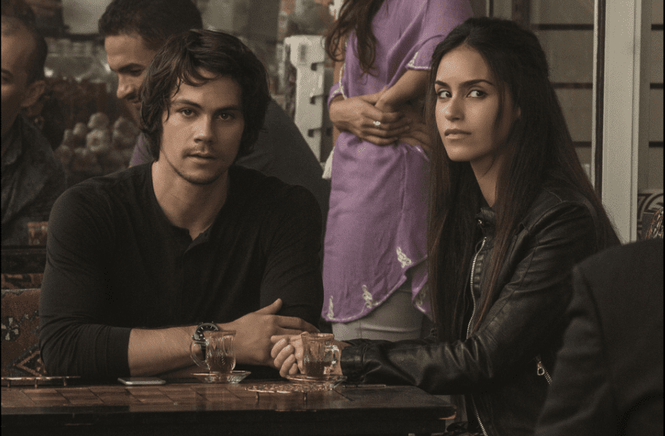 A man and woman sit together at an outdoor cafe in this image from Lionsgate.