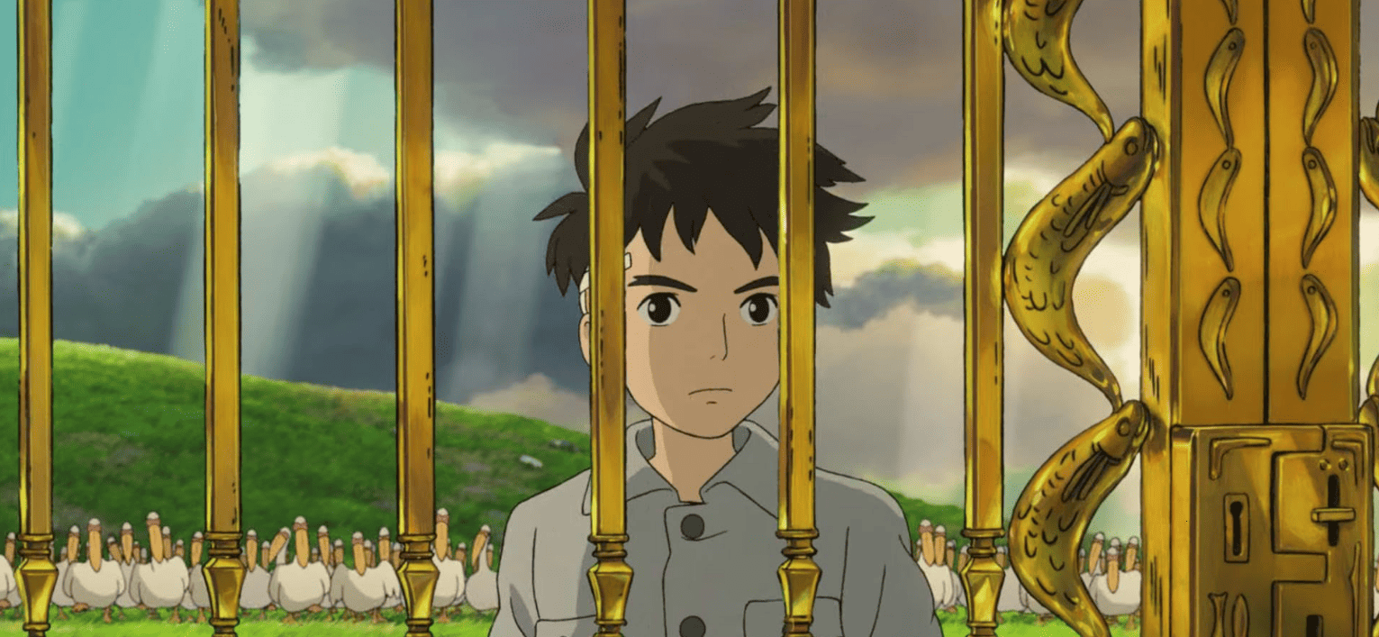 An animated boy stands behind a golden gate in this image from Studio Ghibli.