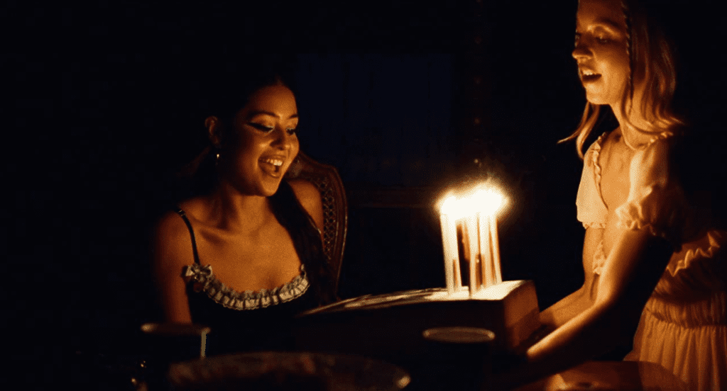 Cassie Howard holding up a birthday cake with candles to Maddy Perez in “Euphoria”