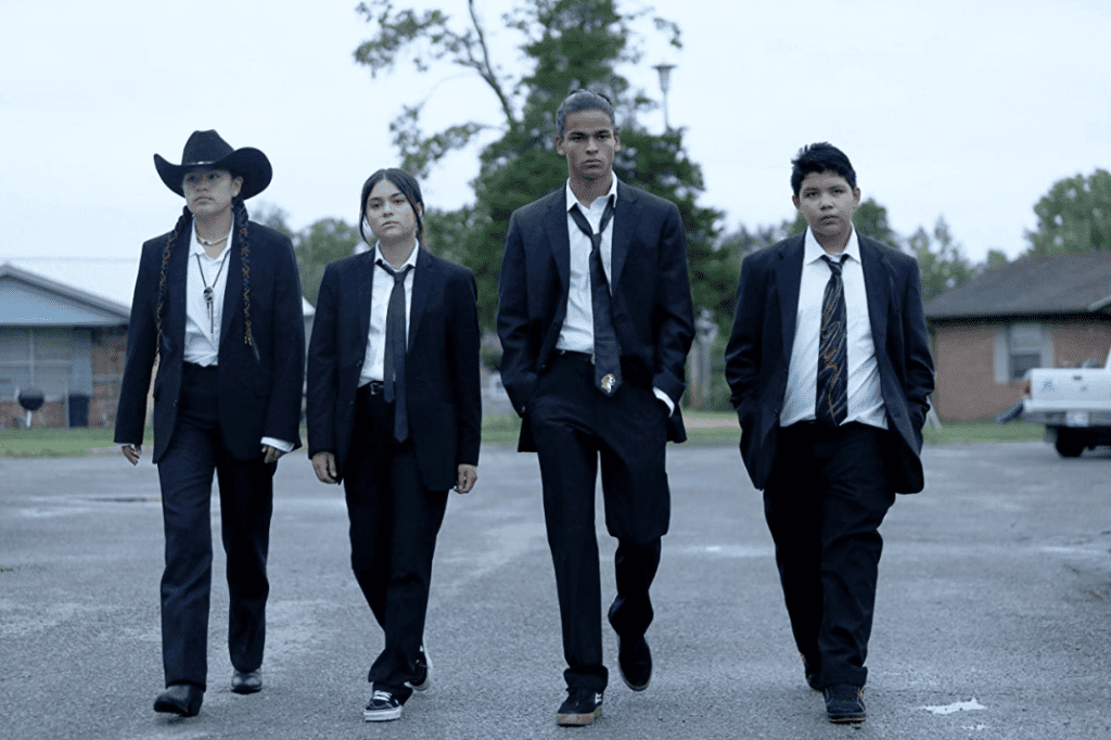 Main characters of “Reservation Dogs” on the street dressed in black suits and ties