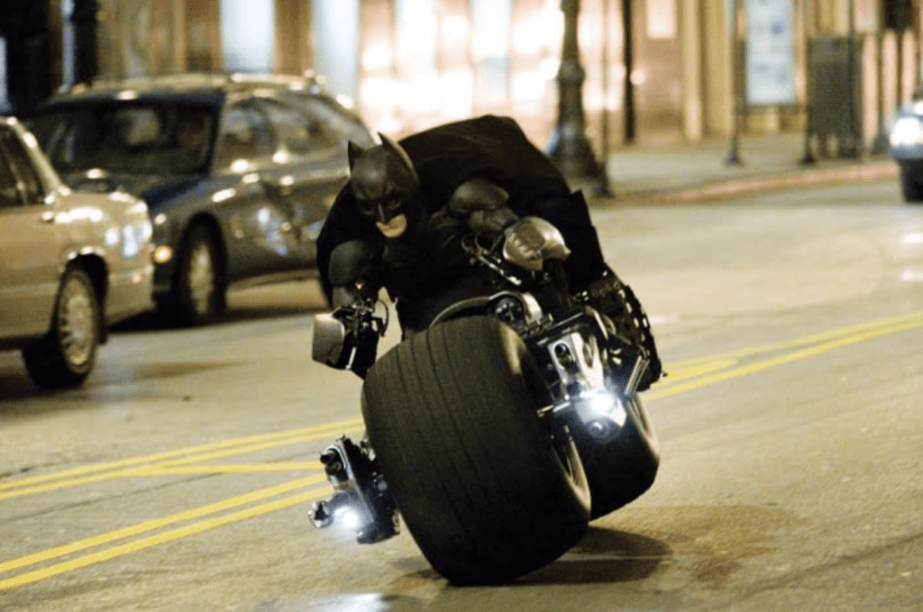  A man speeds down the street on a motorcycle with super thick tires in this image from Warner Bros. Pictures.