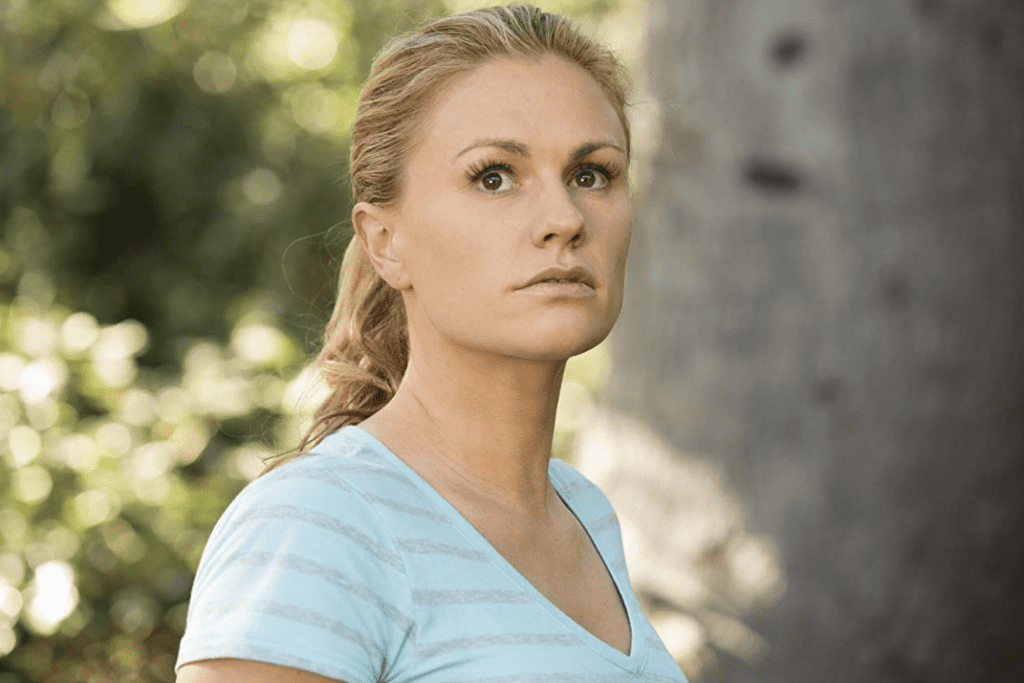 A woman with blonde hair in a blue and gray striped shirt looks at something off-screen in this image from Your Face Goes Here Entertainment.