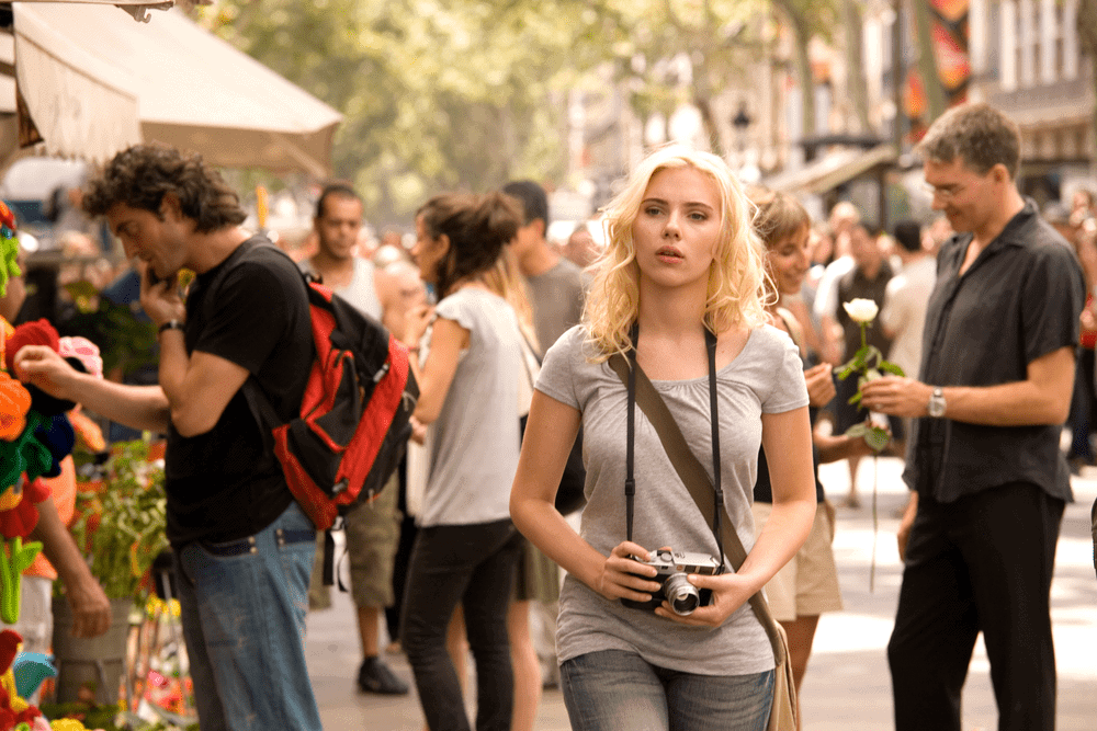 Cristina walking along La Rambla with a camera 