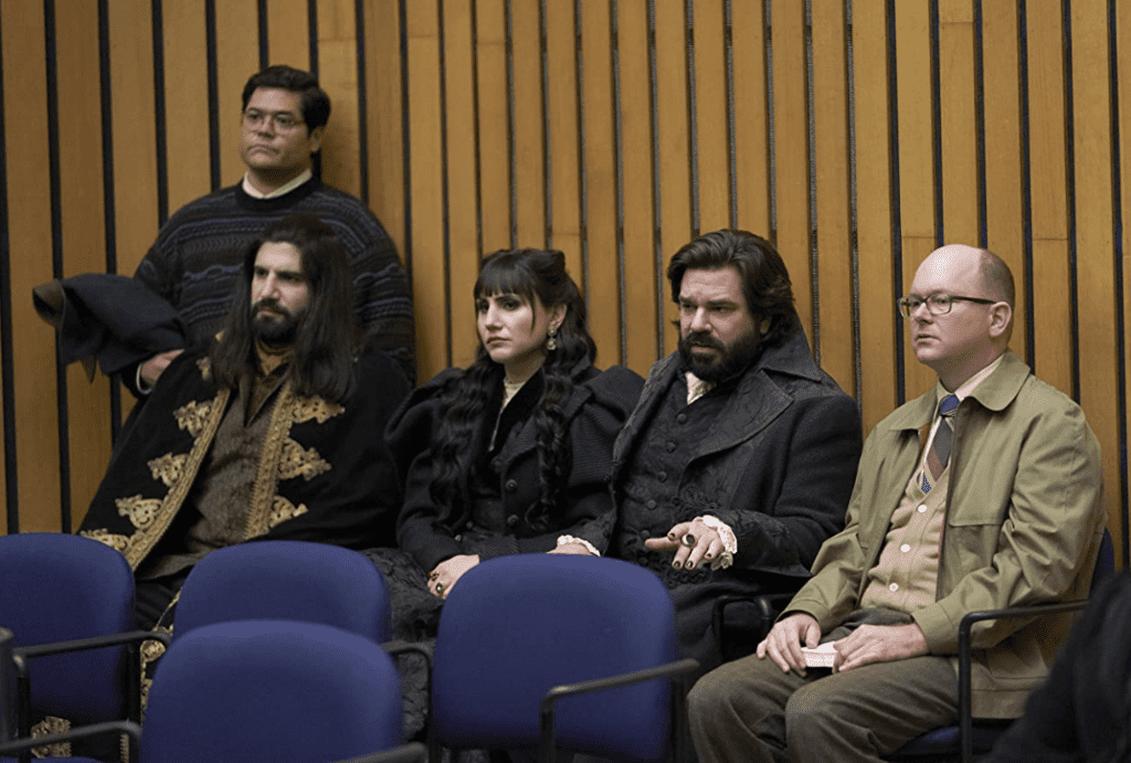 The main cast of “What We Do in the Shadows” waiting to speak at a city council meeting