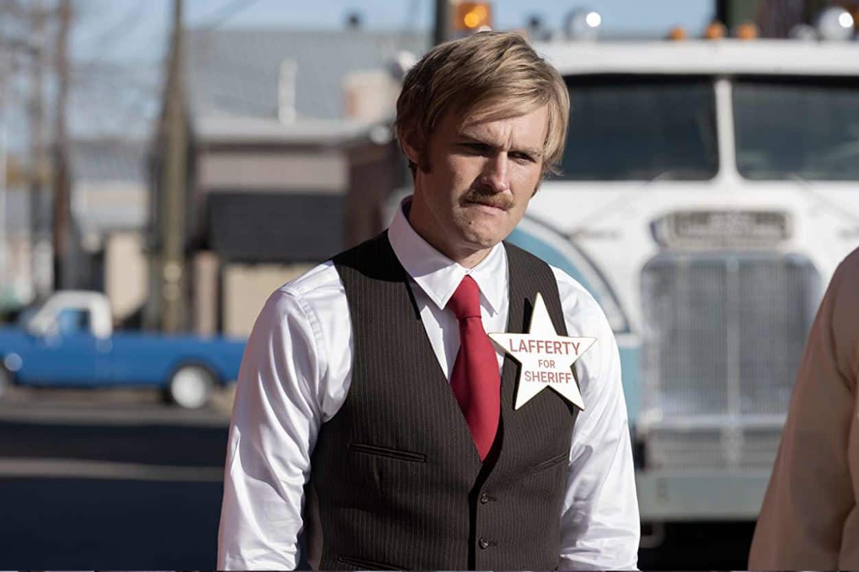 Dan Lafferty in a vest and tie campaigning for sheriff in the show “Under the Banner of Heaven”