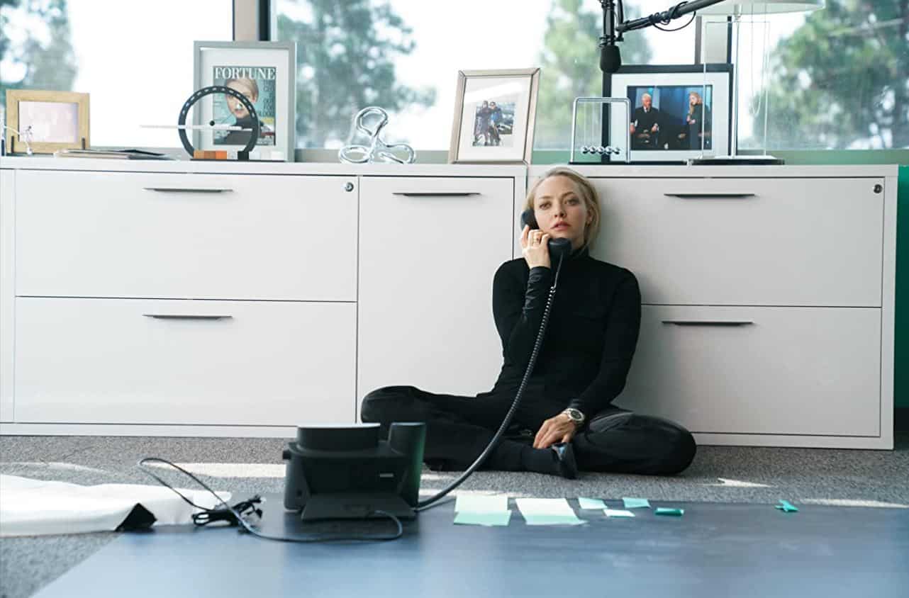 Elizabeth Holmes sitting on the floor of her office talking on the phone in the show “The Dropout”