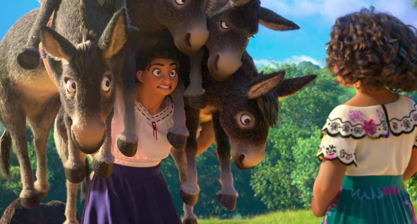 Luisa carries a pile of donkeys on her shoulders while talking to Mirabel