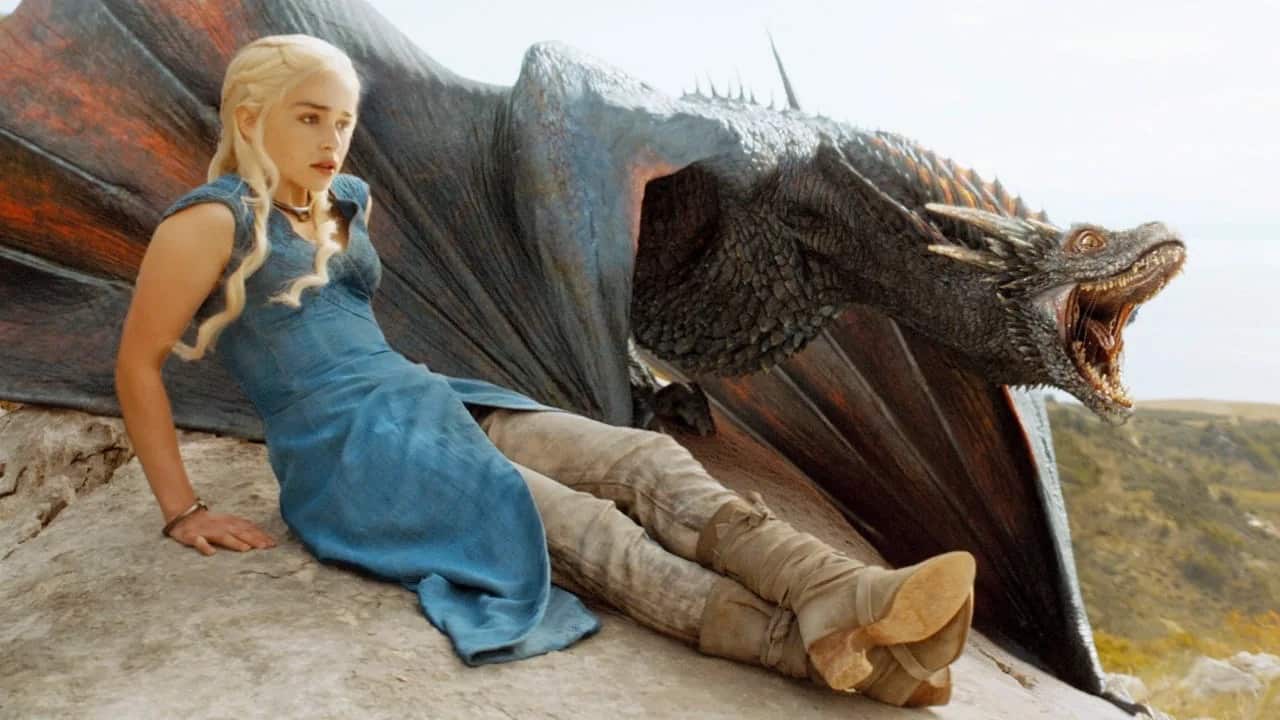Daenerys and Drogon sitting on a boulder