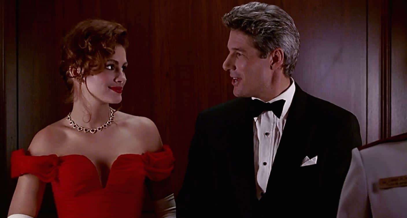 A woman in a red strapless dress smiles at a man wearing a tux in this image from Touchstone Pictures.