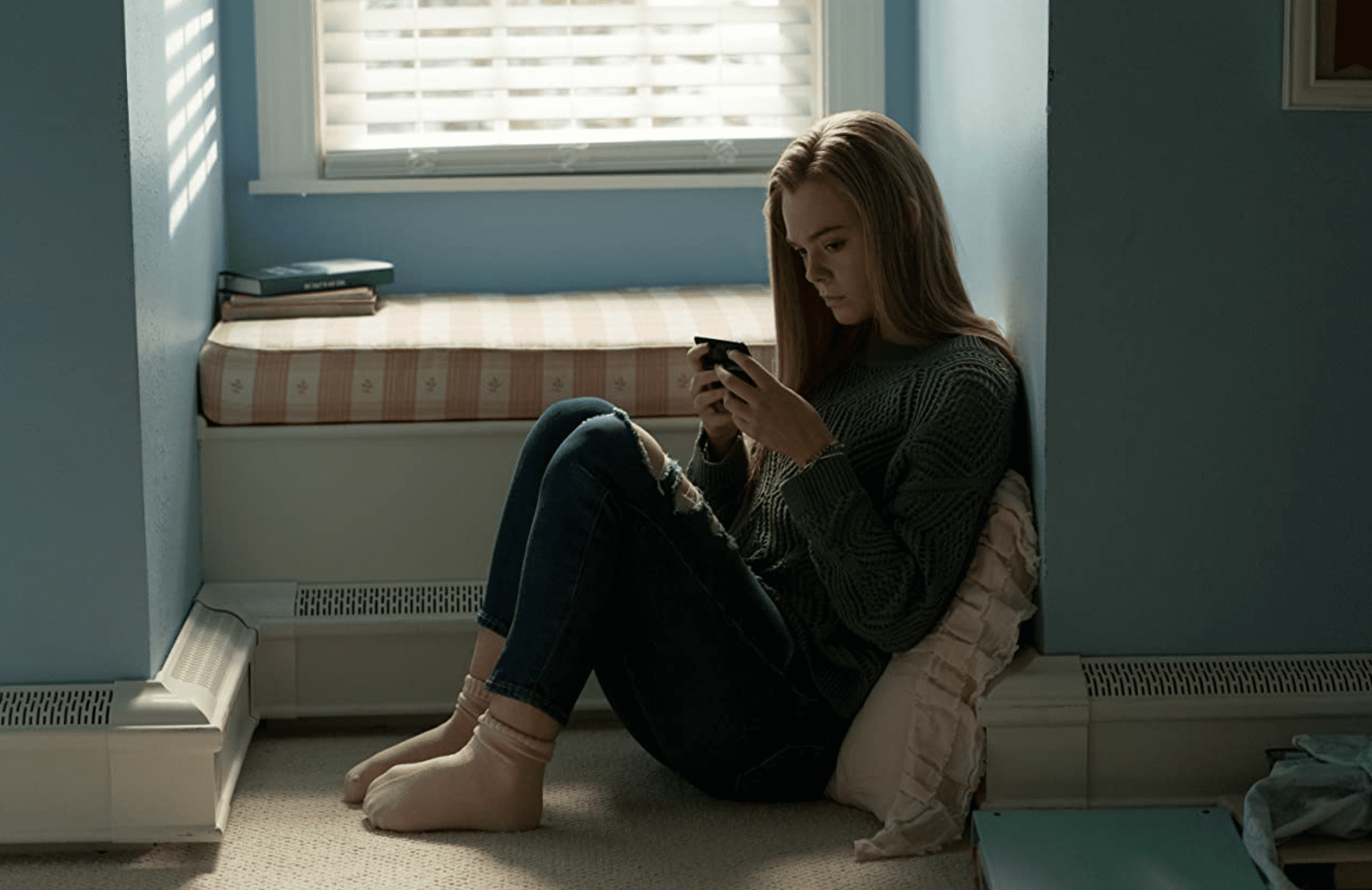 Michelle sits on her bedroom floor and texts