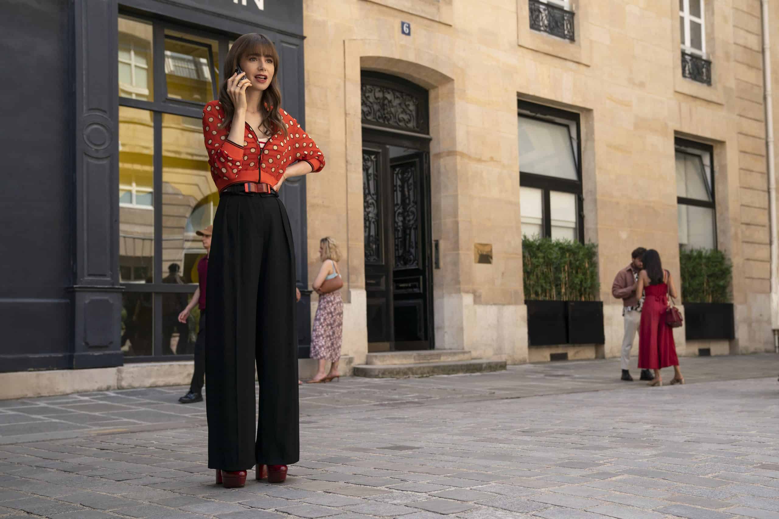 Emily looking fashionable while talking on the phone in a Paris square