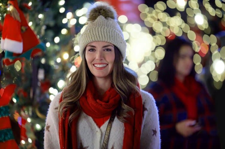 Haley in a hat and scarf standing in front of a Christmas display