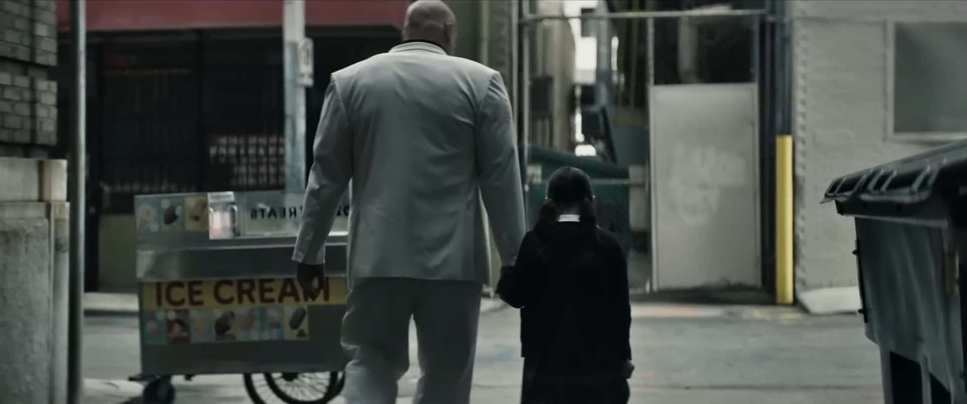 A man and a girl walk down an alley in this image from Marvel Studios. 