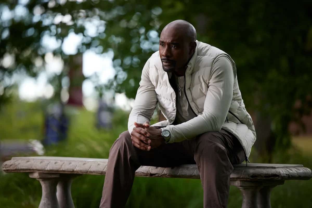 Lance looking concerned while sitting on an outdoor bench