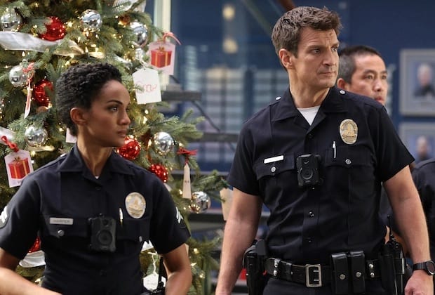 Harper and Nolan stand by a Christmas tree at the station.