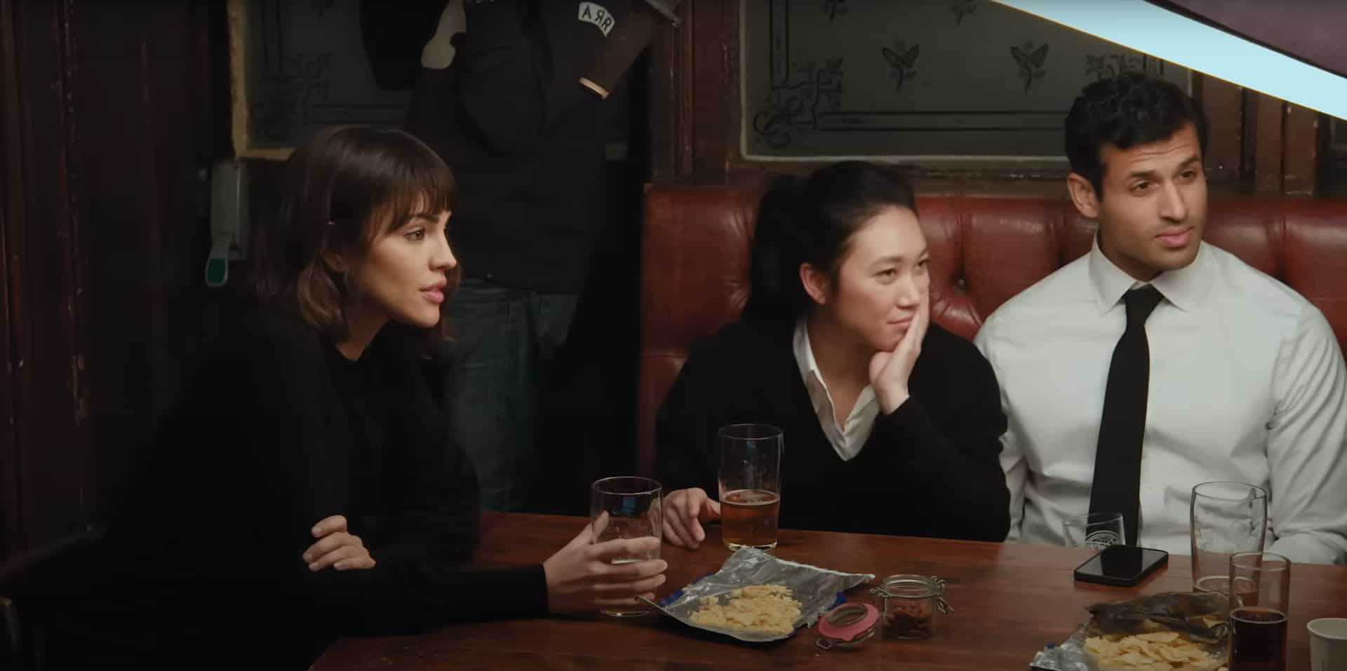 Three friends having drinks and appetizers at a bar
