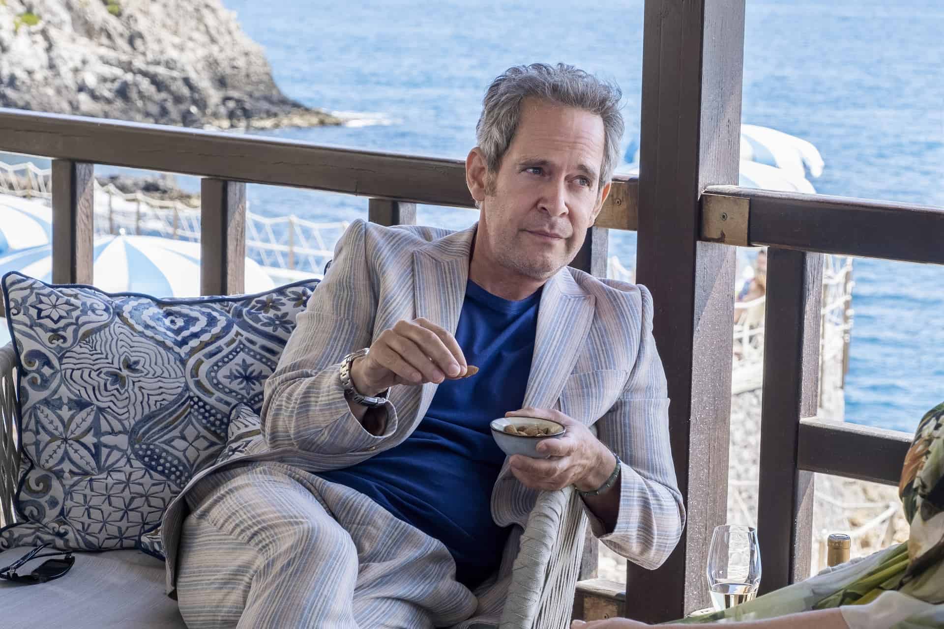 Quentin eating nuts on a beachside deck