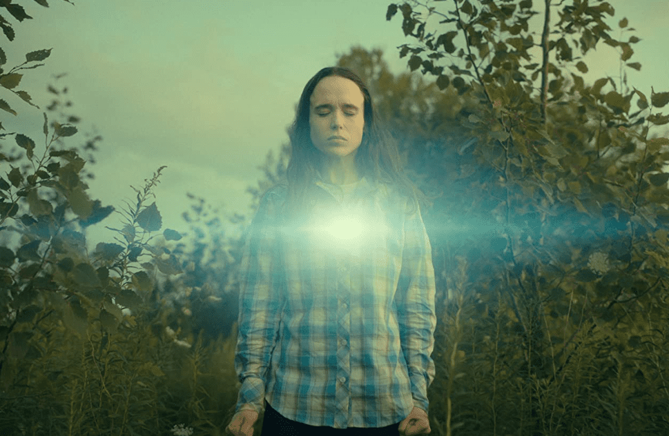  A man with long hair stands in a field with a light shining from his chest in this image from Irish Cowboy Productions.