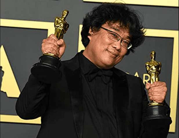 Bong Joon Ho holding two Oscars