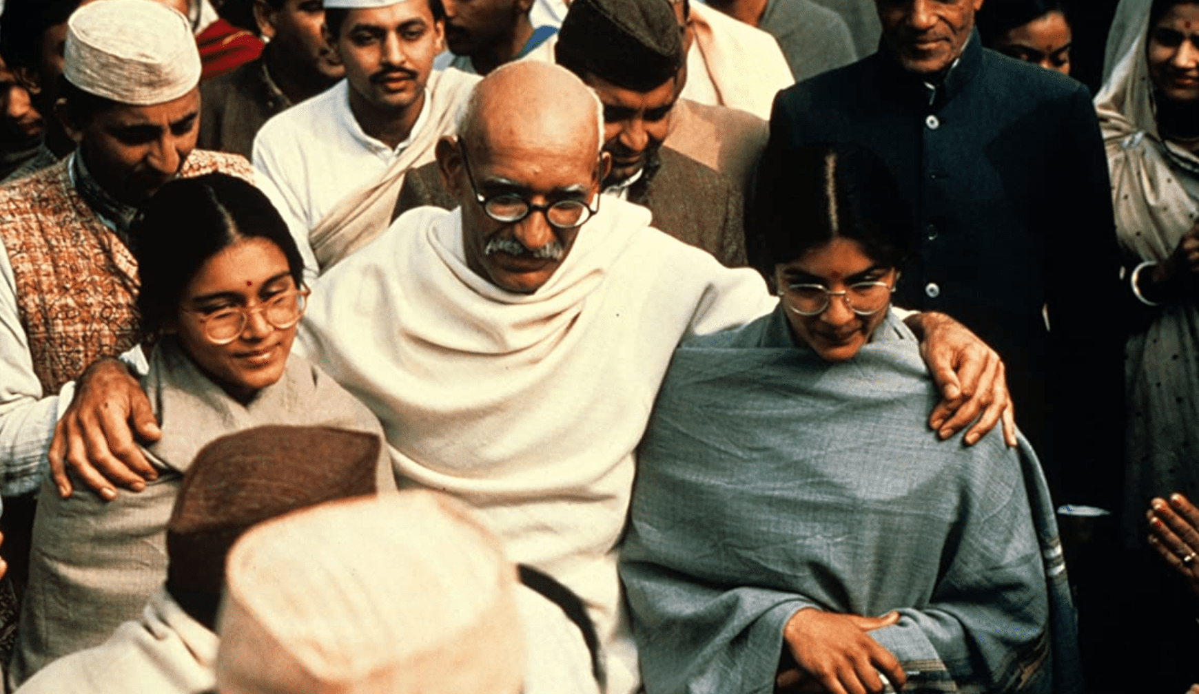 Ben Kingsley, playing Gandhi, embraces two female supporters