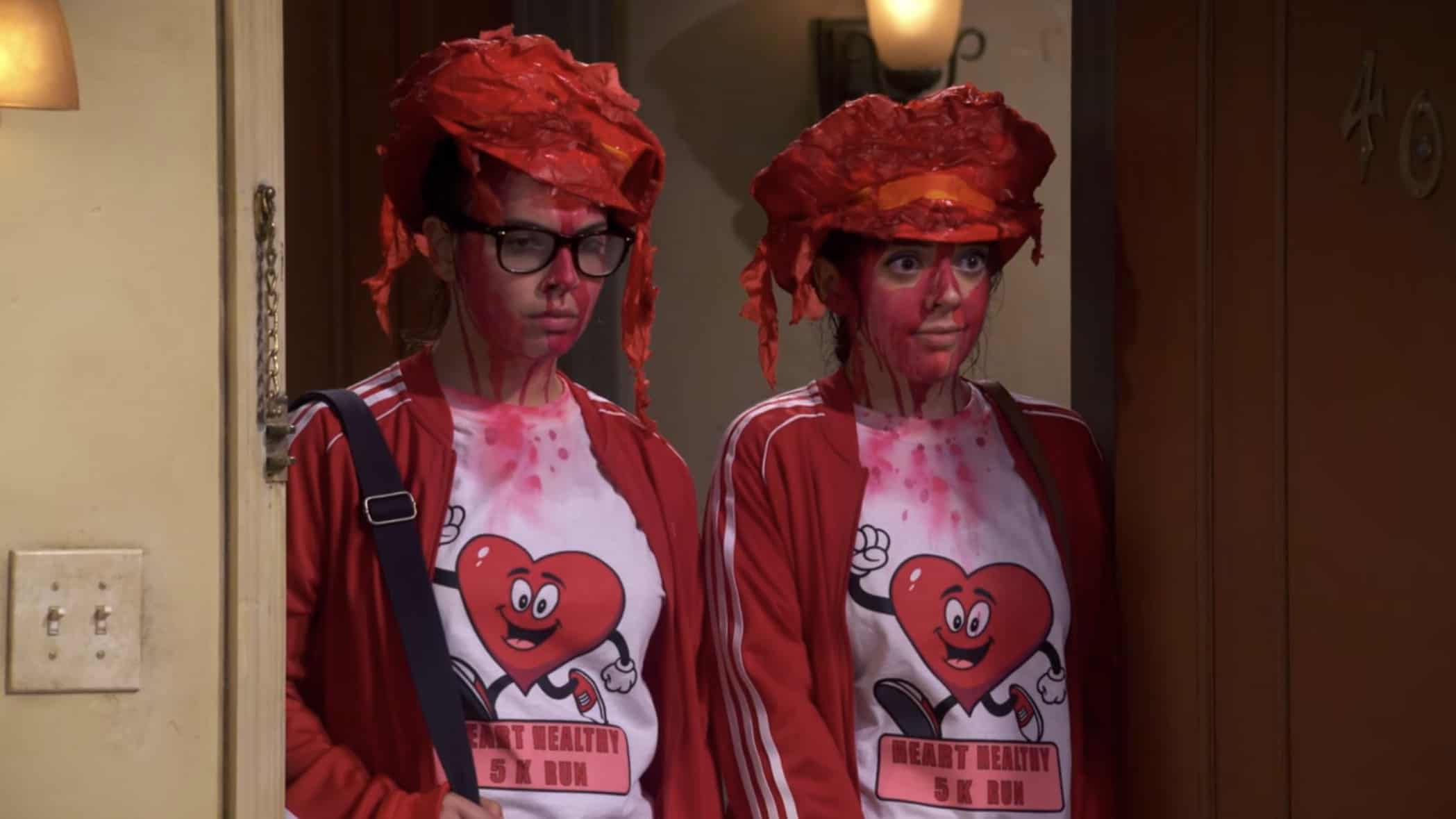 Two teenagers standing in an apartment doorway, wearing red outfits in this image from Netflix