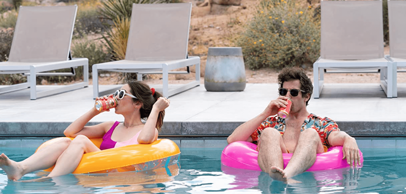 A woman and man lounging on rafts in a pool