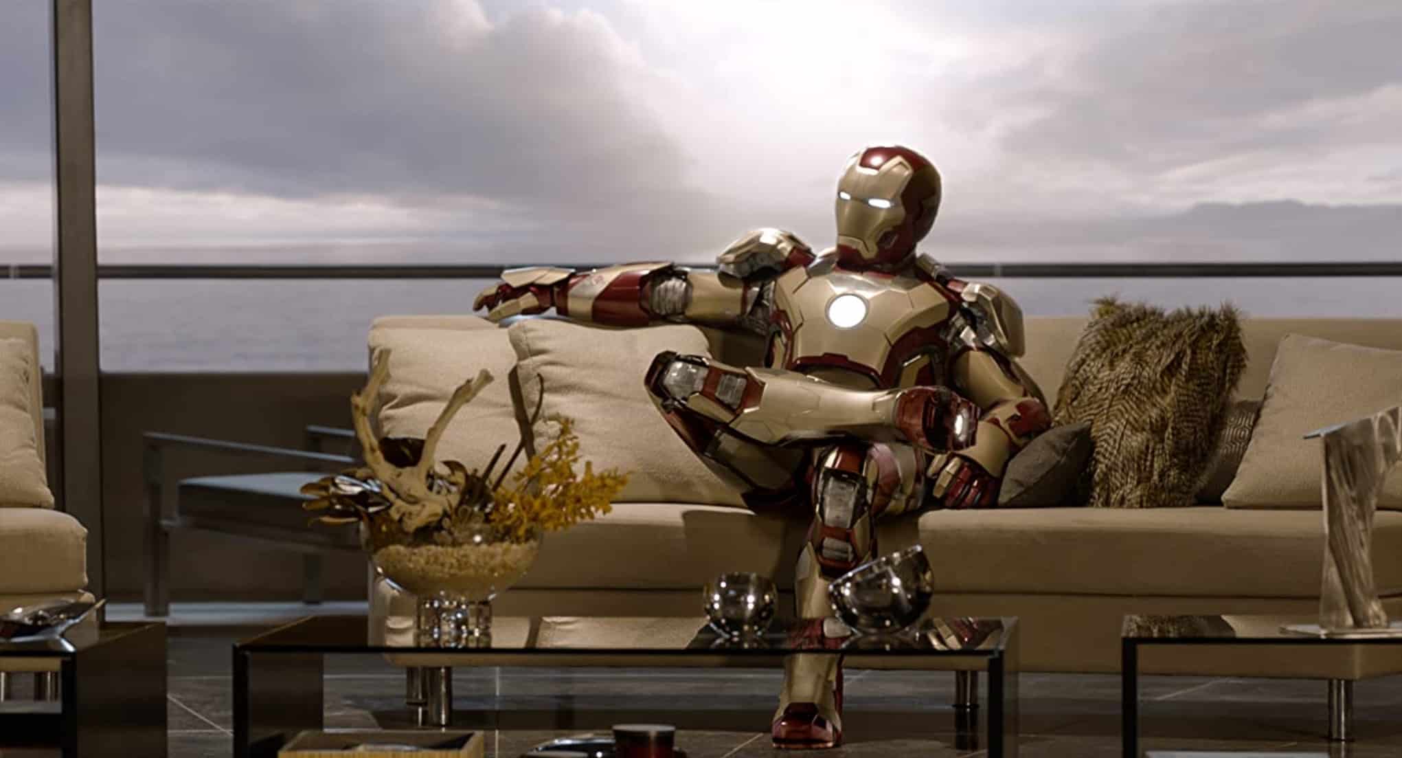 A man in a mechanized suit sits on a couch in this image from Disney Plus
