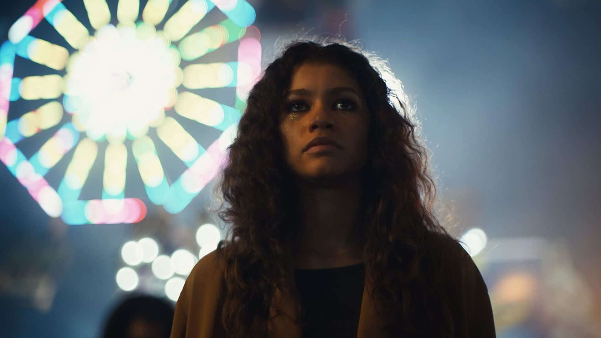 Rue Bennett is standing in front of a Ferris Wheel at night in this image from HBO.
