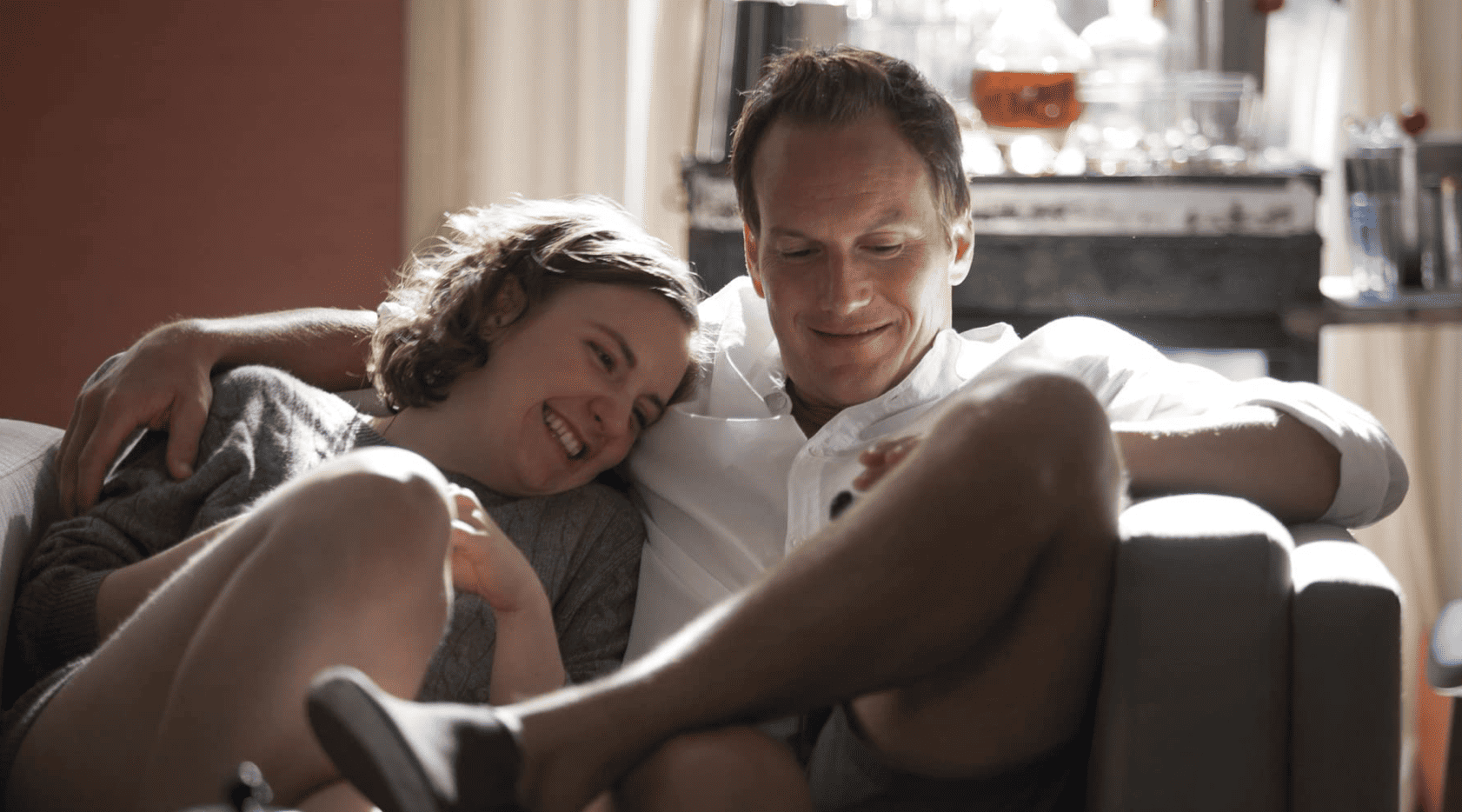 Hannah and Joshua cuddle and laugh together in this image from Apatow Productions