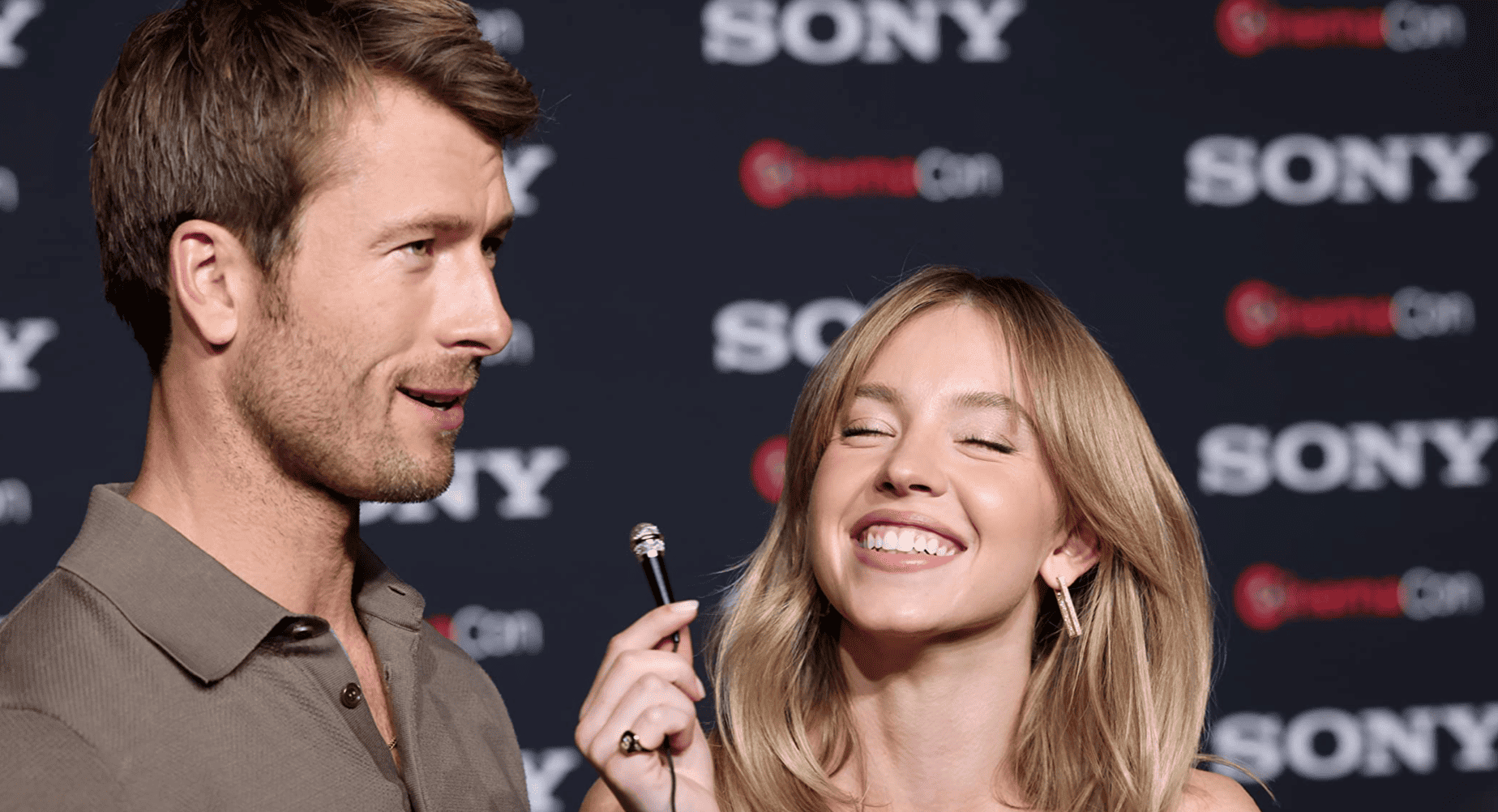 Sydney Sweeney holds up a mini mic with Glen Powell in this image from Sony Pictures.