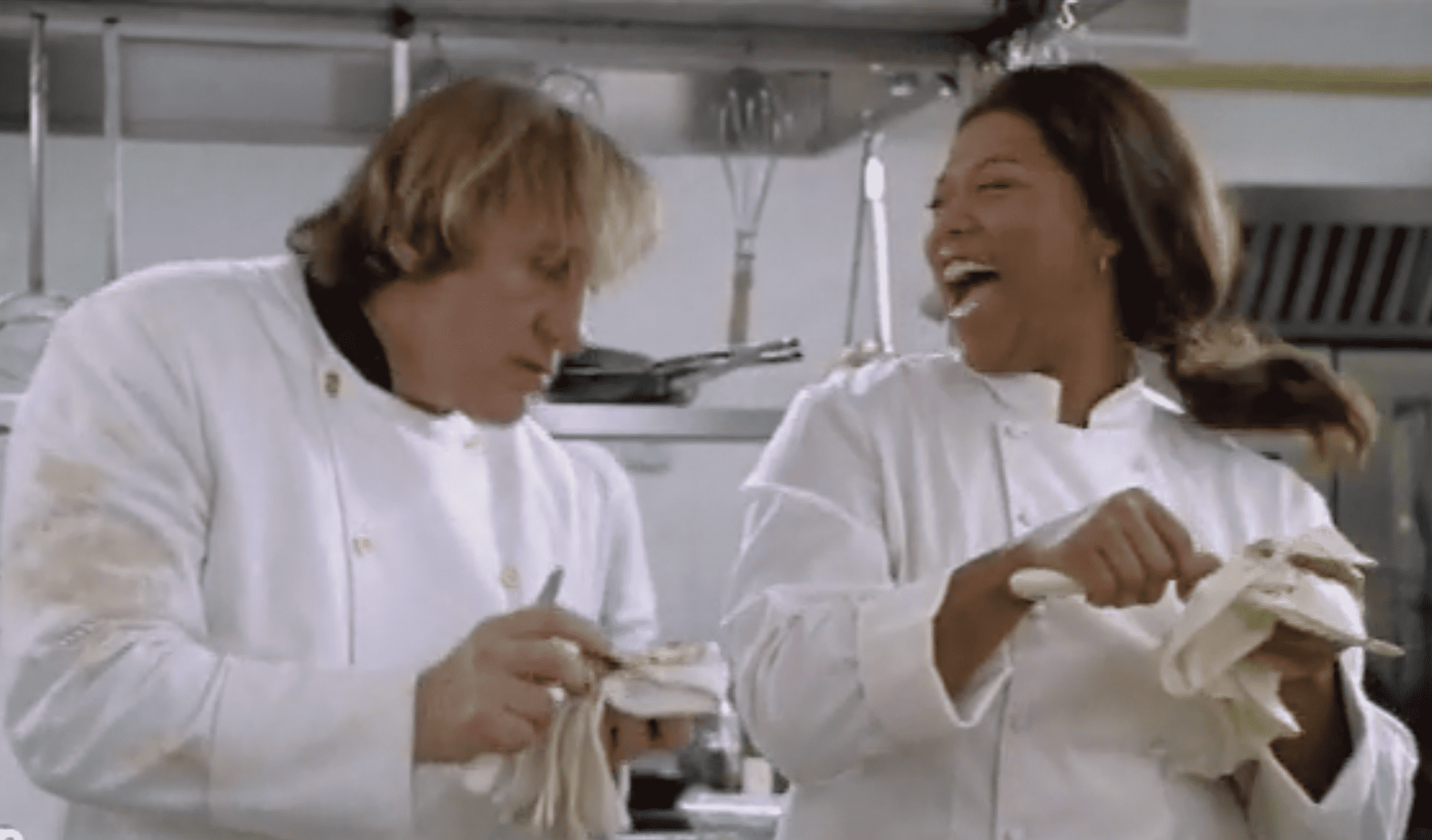Two chefs chat and laugh in a kitchen in this image from Paramount Plus