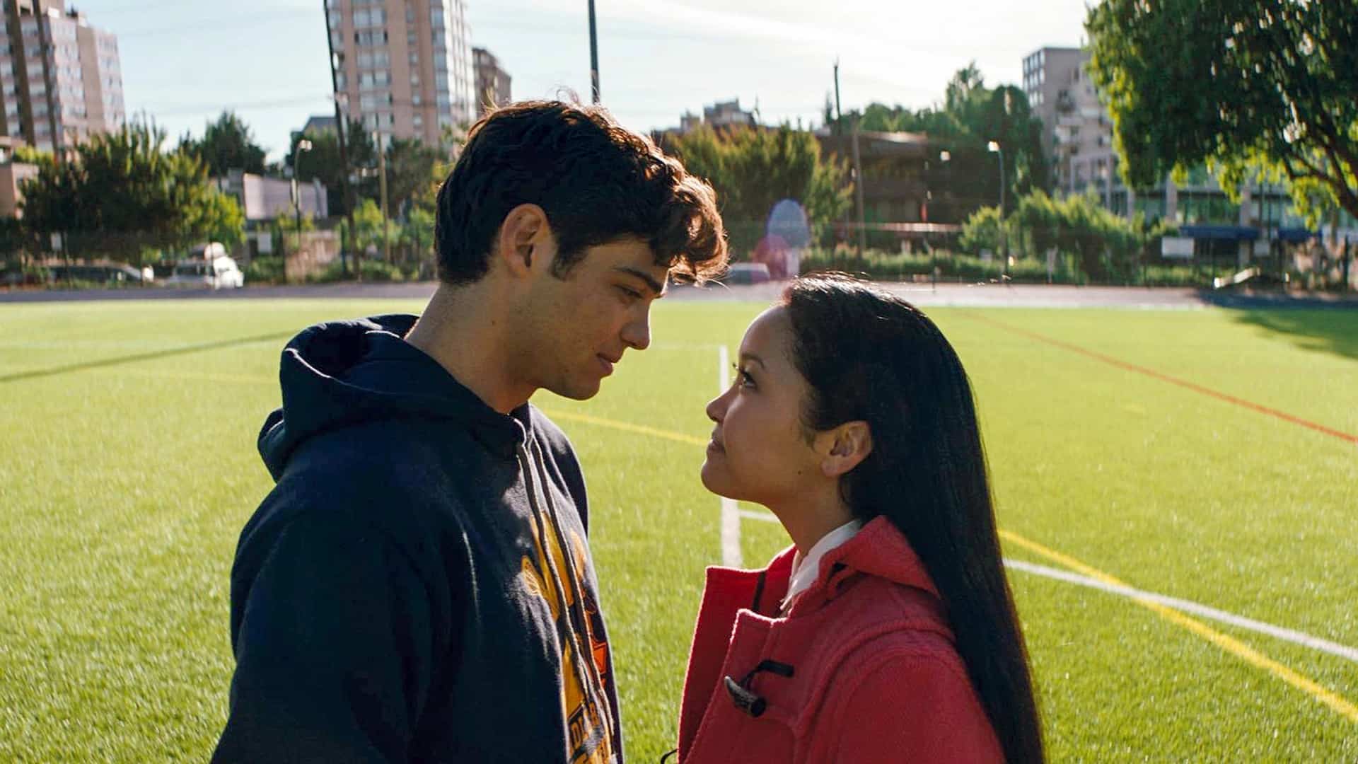 A boy and girl stand on a school field looking at each other in this image from Netflix