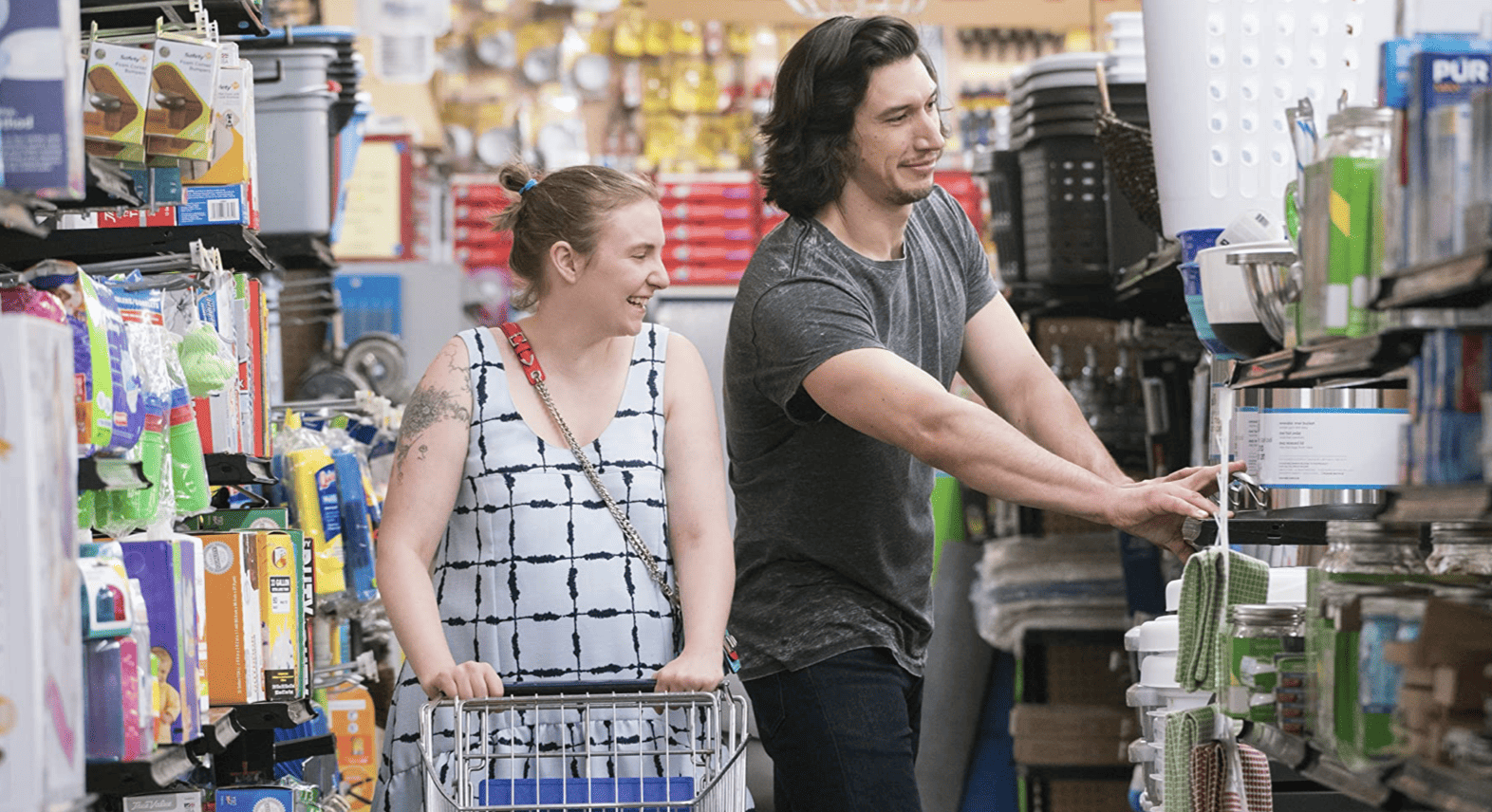 Hannah and Adam pushing a cart in a store in this image from Apatow Productions