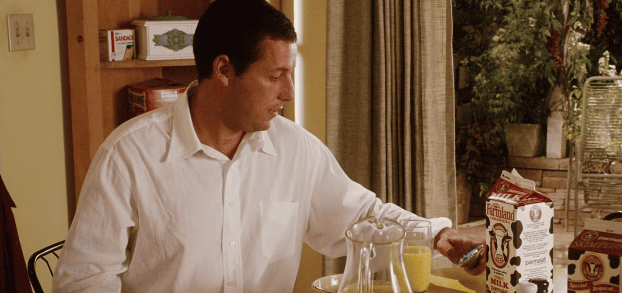 Adam Sandler as Michael Newman sitting at his kitchen table holding a magical remote in this image from Columbia Pictures