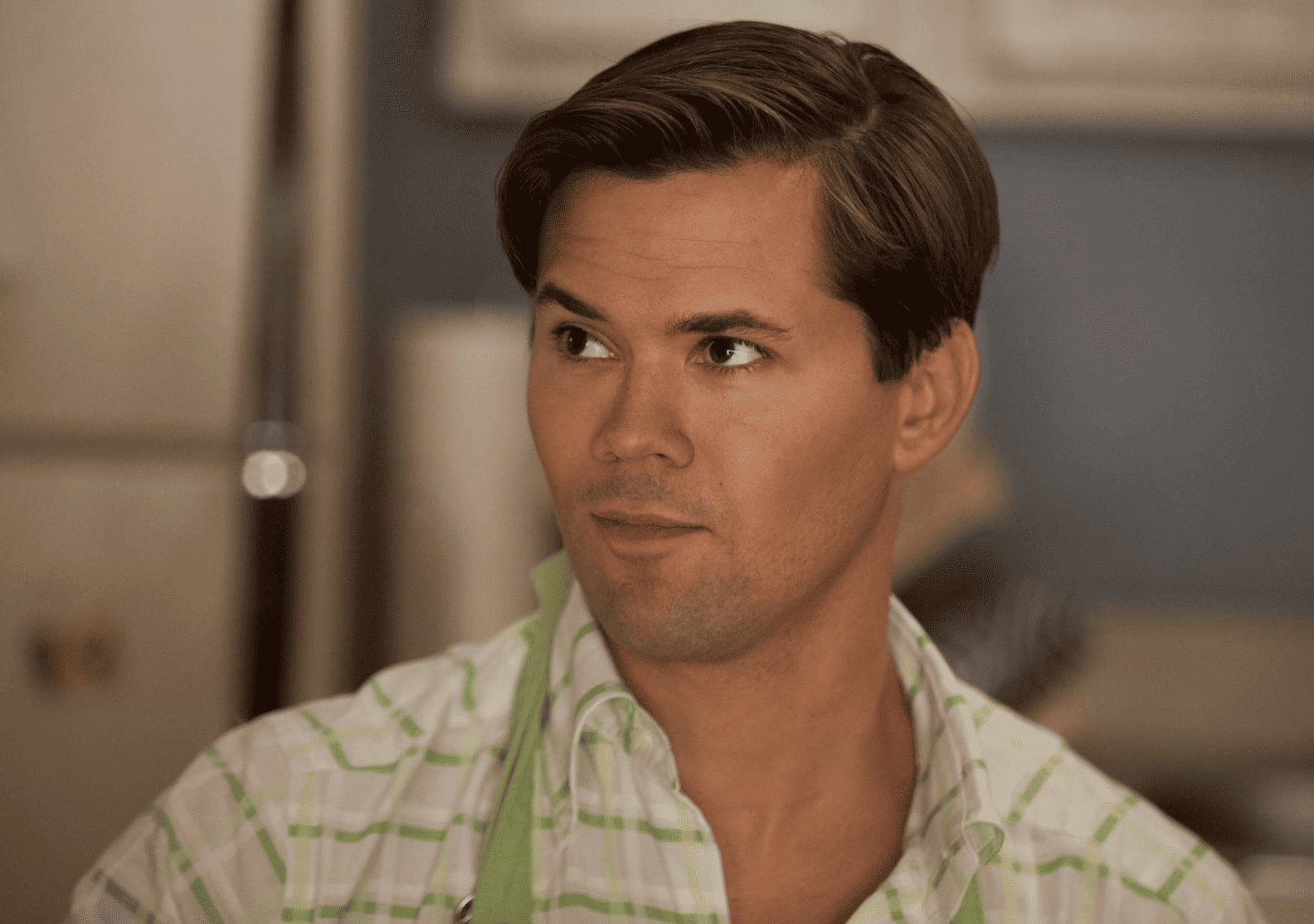 Elijah cooking while wearing an apron in Hannah’s kitchen in this image from Apatow Productions