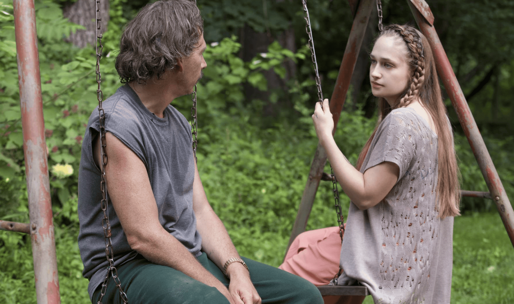 Jessa Johansson on a swing staring at a man in this image from Apatow Productions