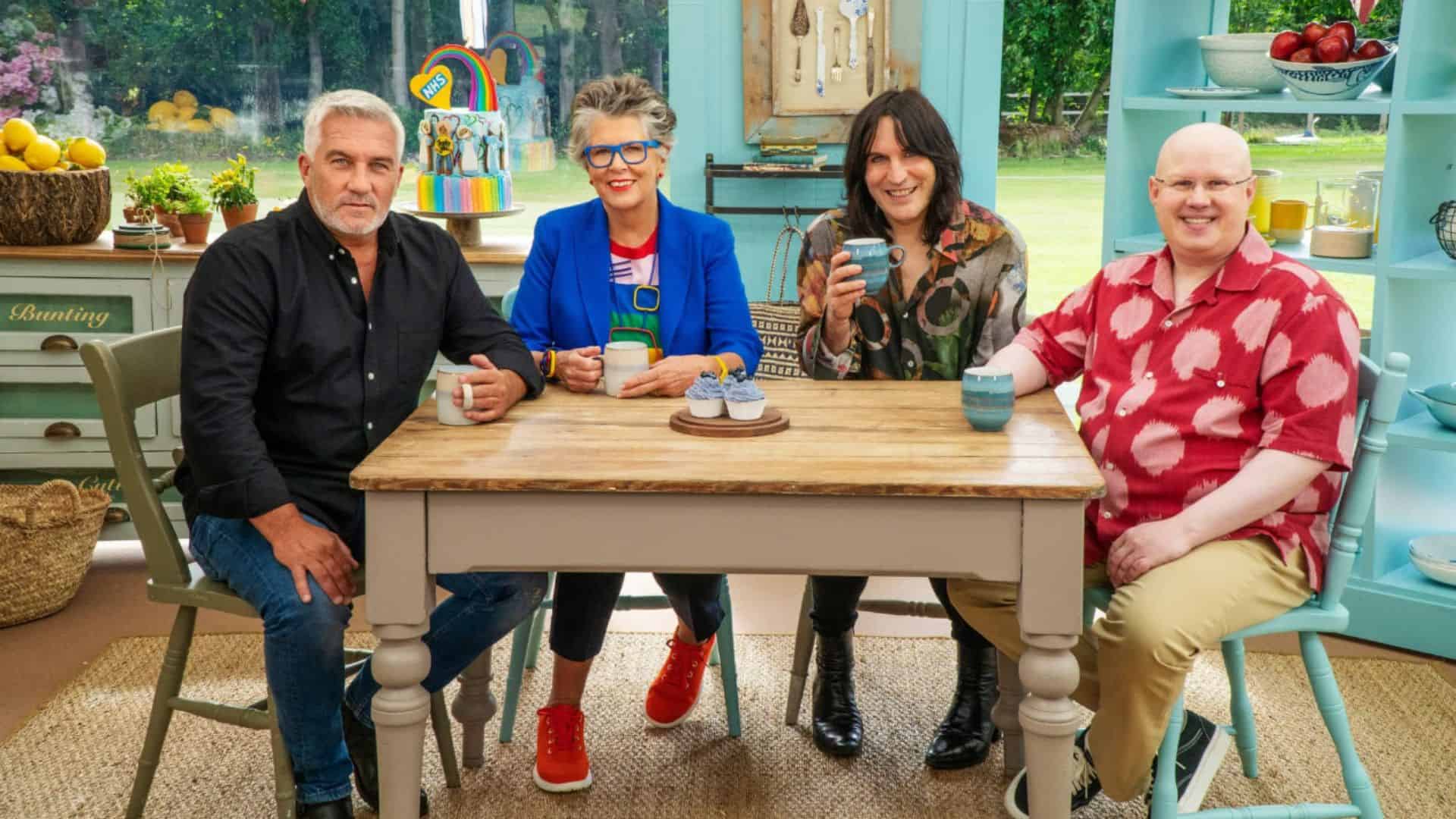 Paul Hollywood, Prue Leith, Noel Fielding, and Matt Lucas sit at a table in the Judges’ Tent in this image from Love Productions.